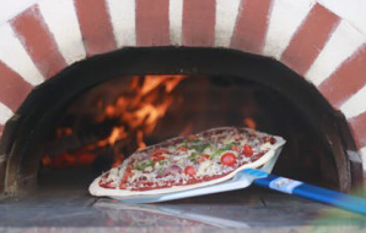 Pizza wird in eine Ofen geschoben