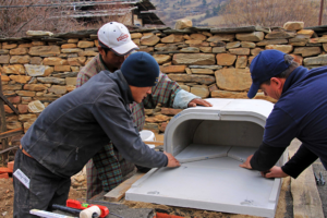 Drei Personen bauen in Bhutan einen ORTNER Holzbackofen auf.